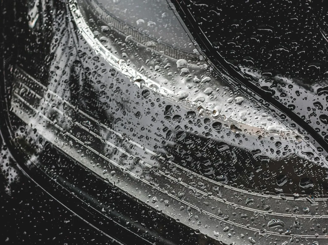 swirl marks visible under a hard light on dark paint, close
