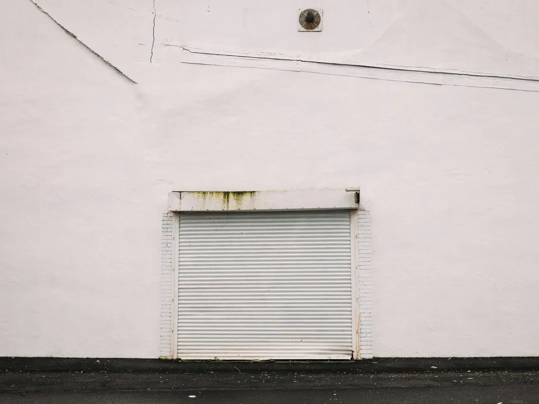 a modern UK trade-park unit exterior with a roller shutter, daylight