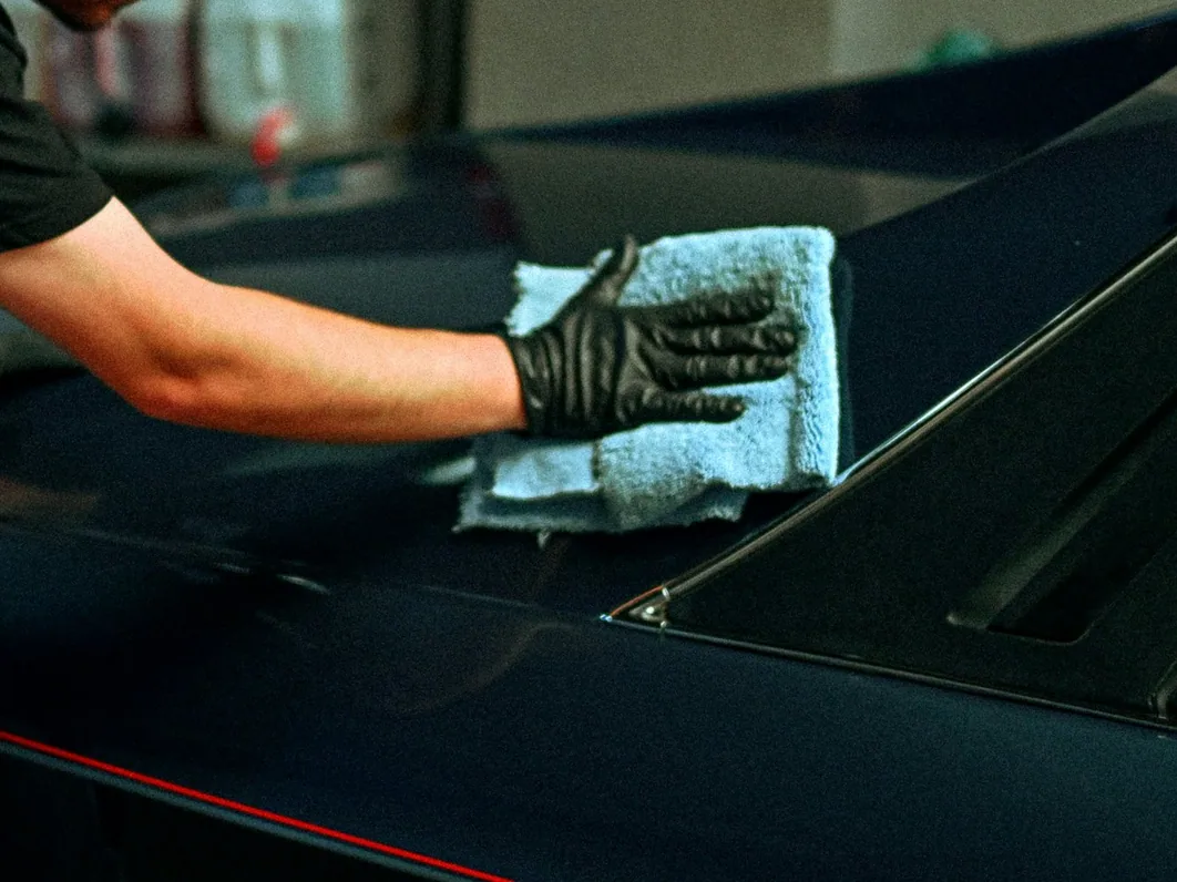 a car being hand-dried with a microfibre towel in the studio